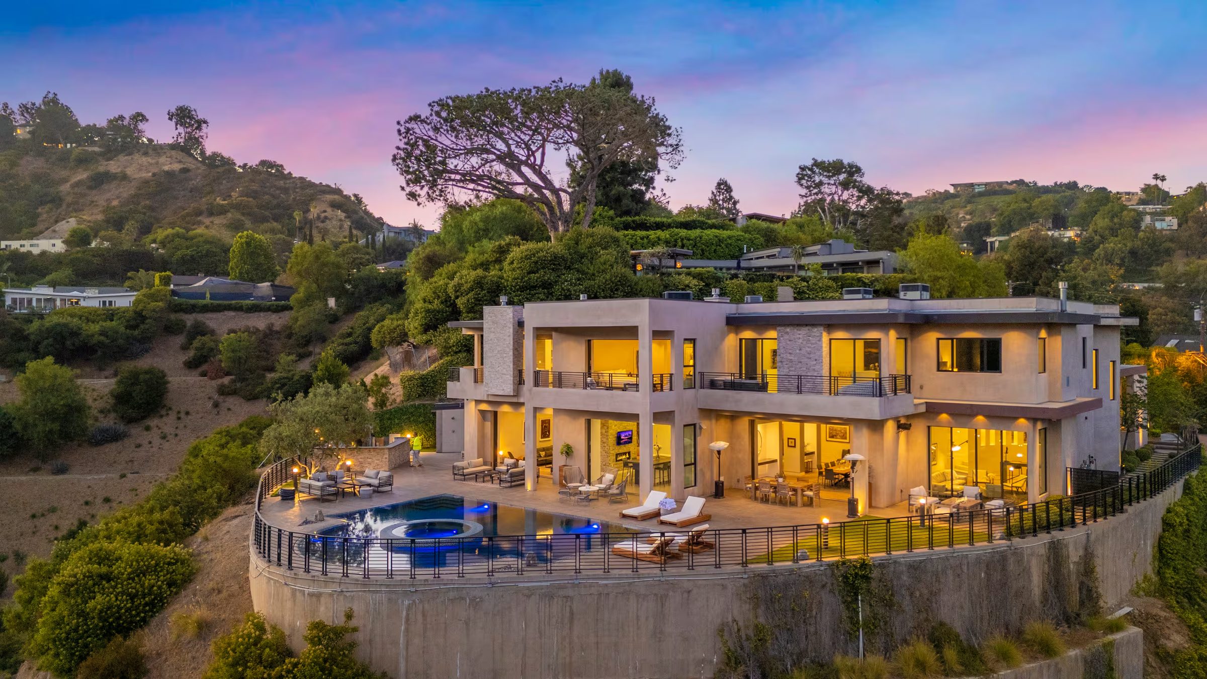 Zorada Villa at dusk on its private terrace above the canyon, lit from within, pool glowing blue